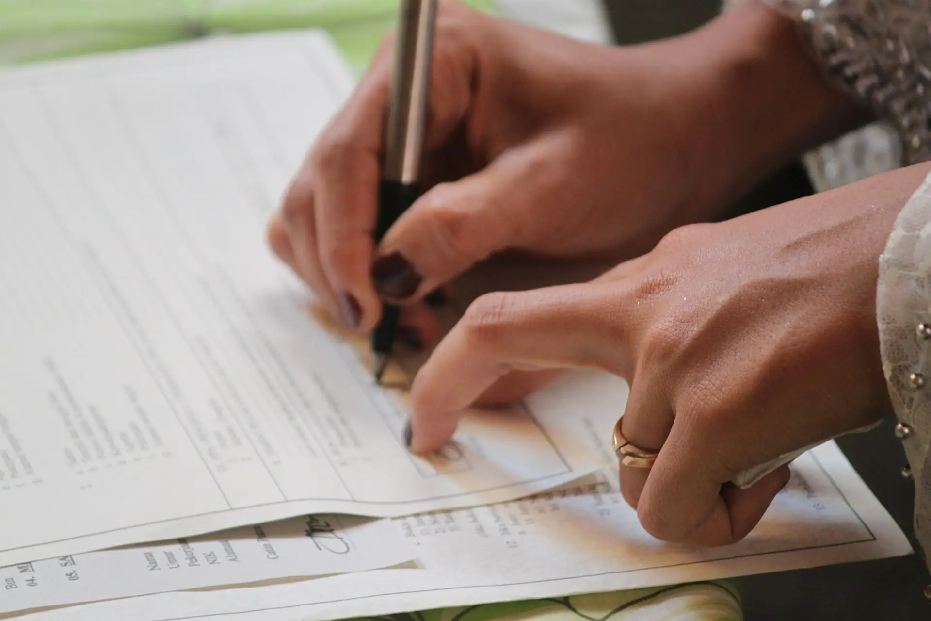 Gros plan sur les mains d'une personne signant un devis papier avec un stylo noir.