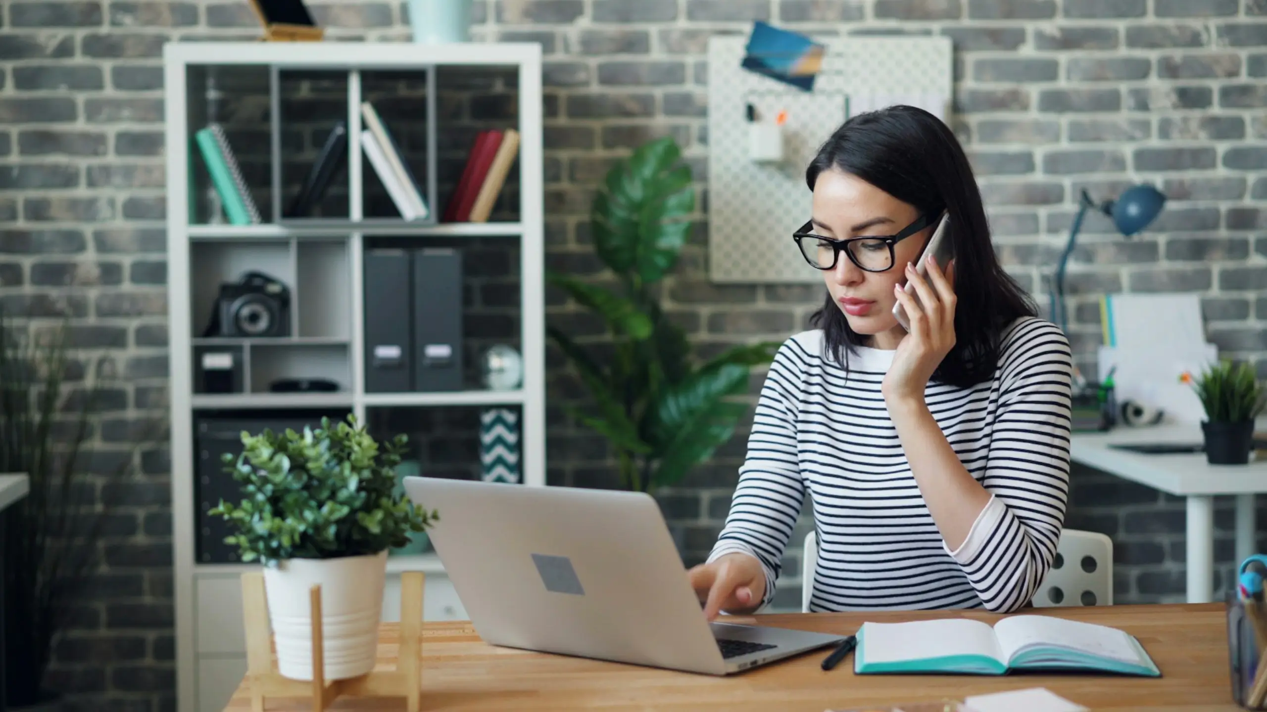 jeune femme travaillant sur son ordinateur en train d'appeler un client pour le relancer de payer une facture en attente de règlement
