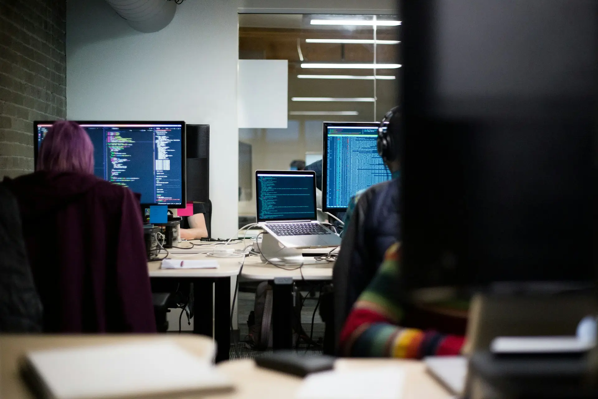 Un professionnel souriant au téléphone devant son ordinateur portable dans un bureau moderne, représentant un échange fluide avec un client grâce au suivi de facturation de CashNow