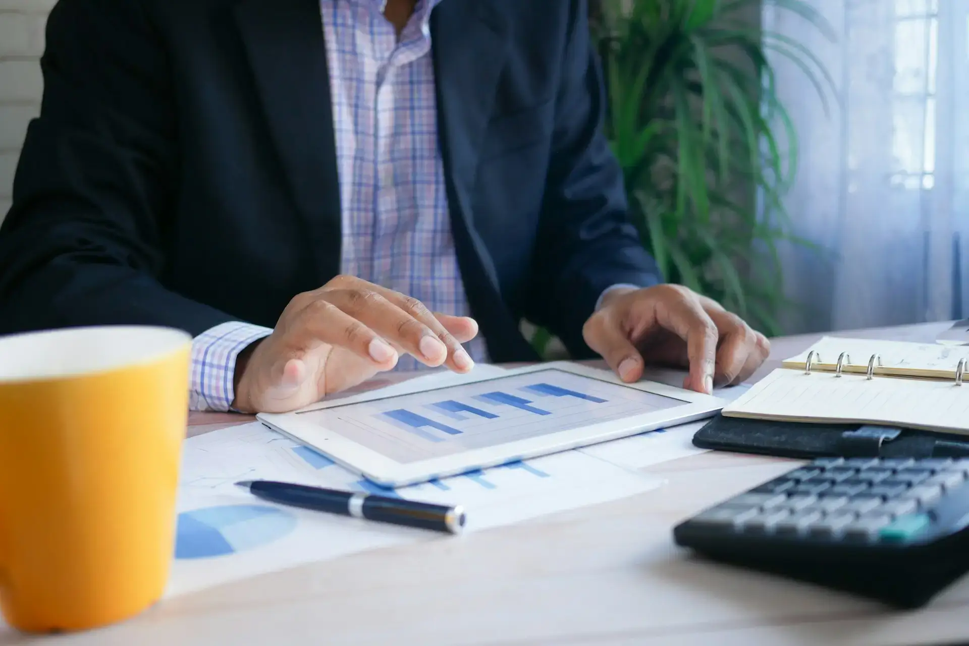 homme d'affaires consultant des graphiques financiers sur une tablette à son bureau